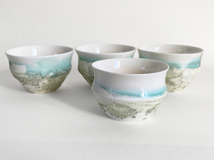 Collection of white porcelain bowls with green crawling effect glaze by Alexandra Ridel