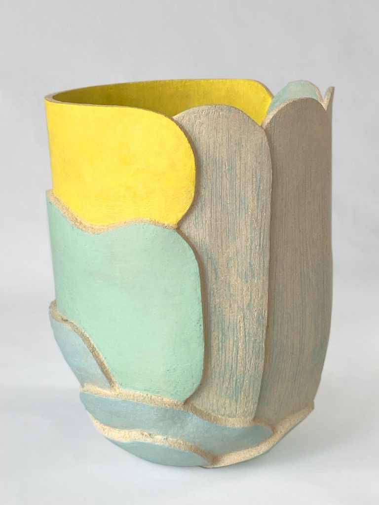 Organic slab-built volume with graphic green lines next to yellow, blue and green stoneware by Alexandra Ridel