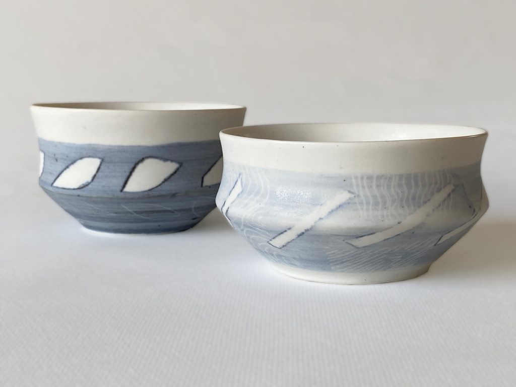 Handleless porcelain cups with graphic decoration and repeating blue leaf motifs, by Alexandra Ridel