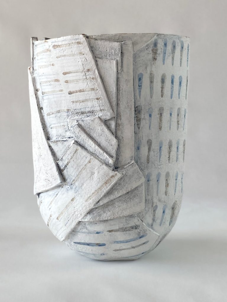 slab-built stoneware piece with drops and lines motifs on a white background